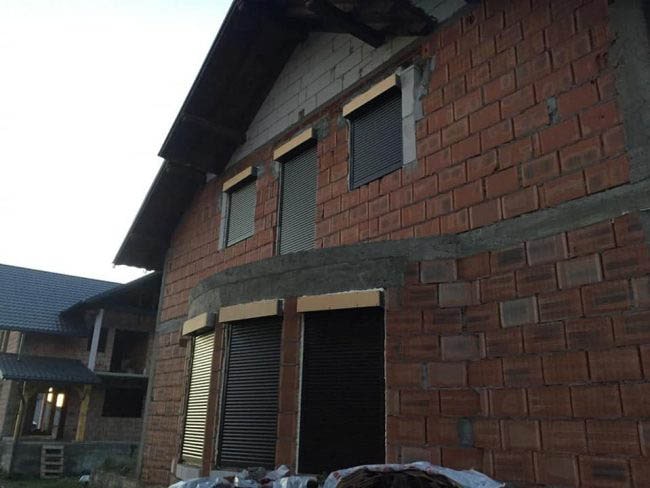 Casa din caramida rosie si acoperis gri cu ferestre si usi termopan maro montate de ifenster beclean